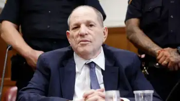 Harvey Weinstein sits in court during his New York sex crimes retrial, flanked by officers.